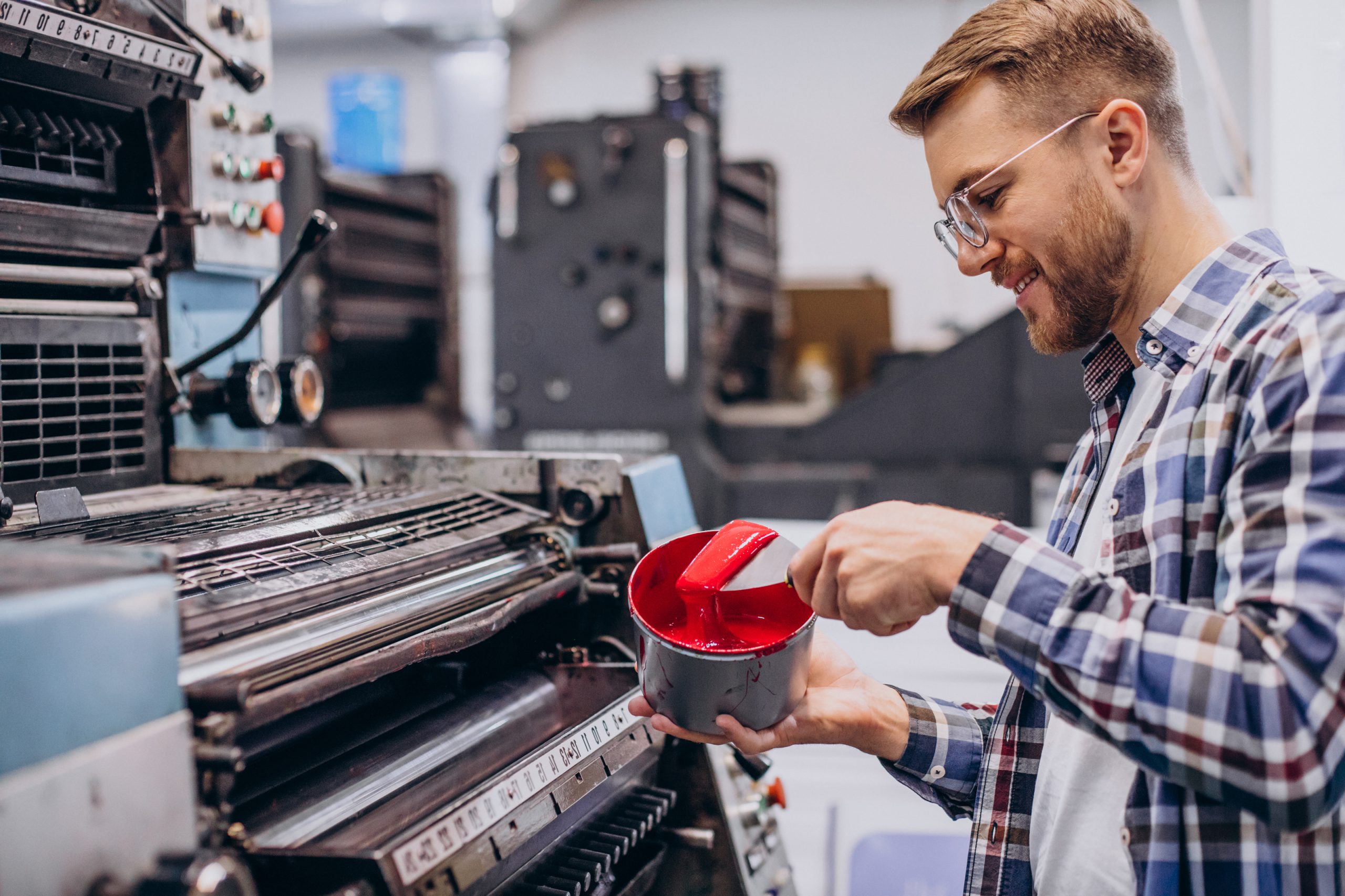 Man working in printing house with paper and paints
